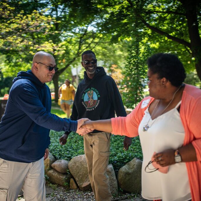 formerly incarcerated people shaking hands and making connection and friends